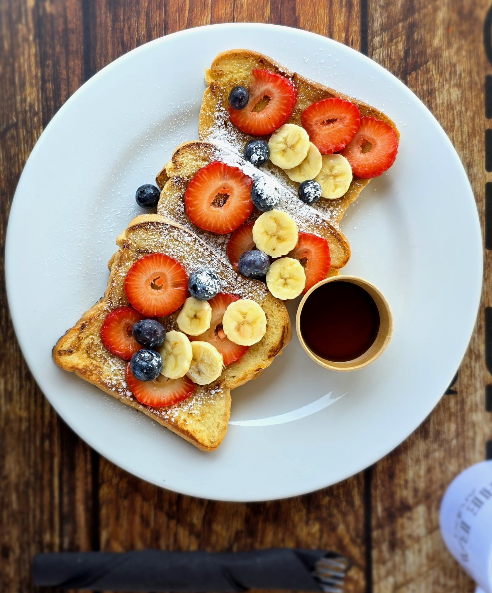 Che Bar Aruba French toast overhead with fresh fruit and maple syrup