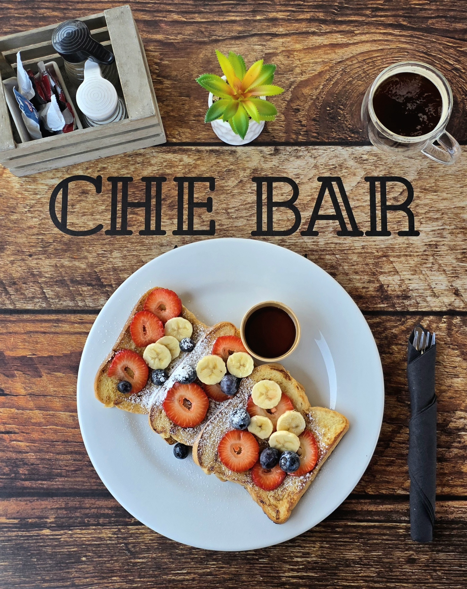Che Bar Aruba French toast with berries and banana on branded table